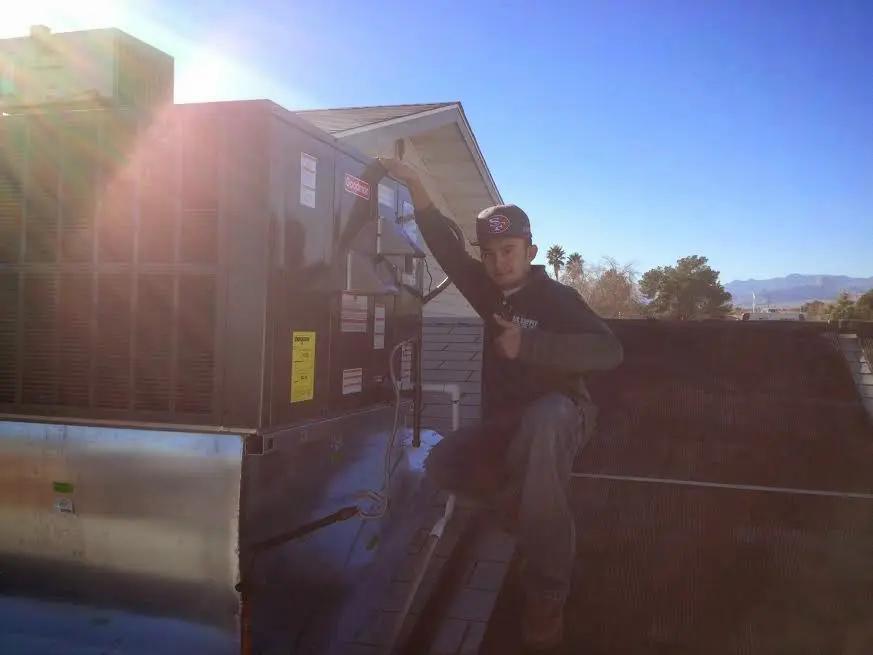 HVAC technician performing Boiler Repair on a rooftop unit in Schuyler